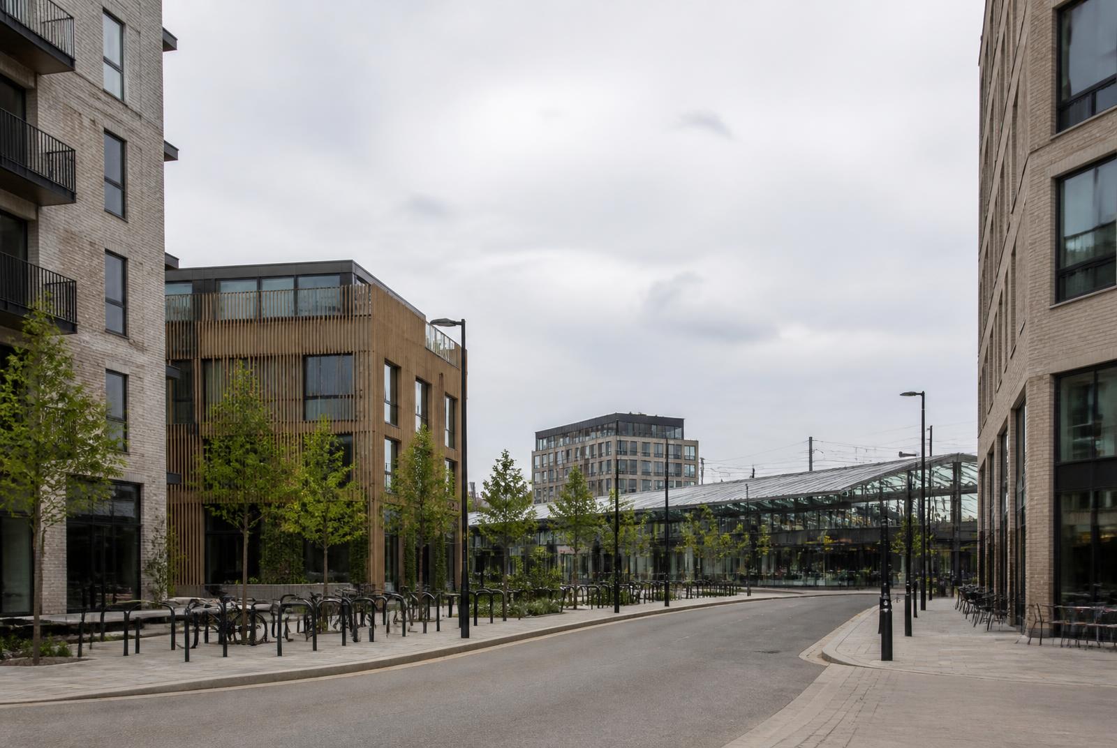Kontor- og næringsbygg langs en gate i et moderne norsk bysentrum med stasjonsområde, likt Asker sentrum