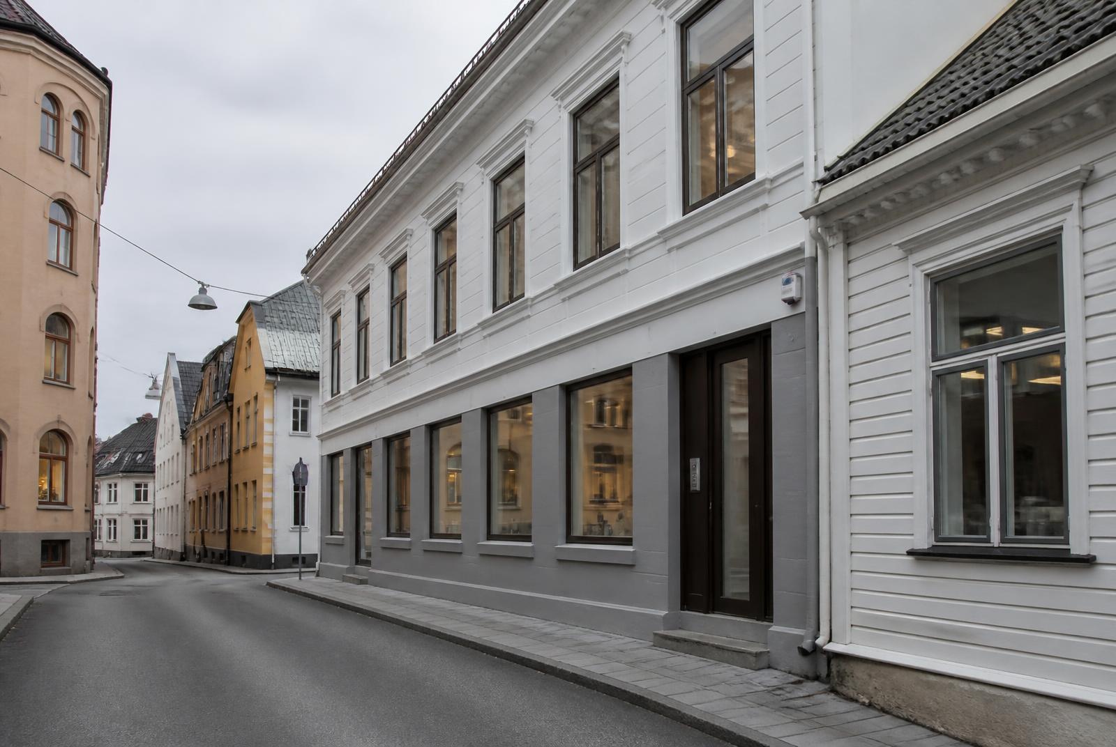 Sentrumsbygg med kontorlokaler og inngang direkte fra gaten i en smal bygate, typisk for kontorflytting i Halden sentrum